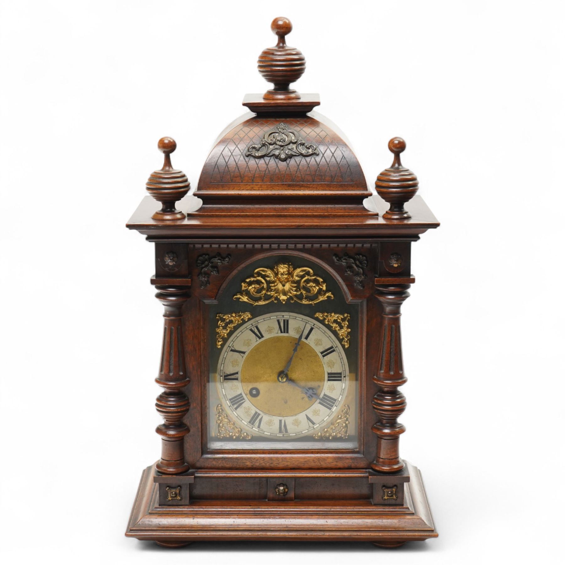 German-Junghans late 19th century oak cased mantle clock, with a domed pediment and three matching turned finials, break arch door beneath with attached turned and tapered pilasters, brass dial with cast spandrels, matted dial centre, steel hands and silvered chapter ring with Roman numerals, two train movement striking the hours and half-hours on a coiled gong. With pendulum and key.