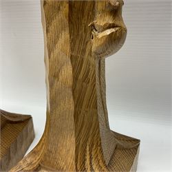 Mouseman - pair of tooled oak candlesticks, wrought iron sconce with drip tray over tapered octagonal column carved with mouse signature, terminating to stylised leaf carved square base, by the workshop of Robert Thompson, Kilburn
