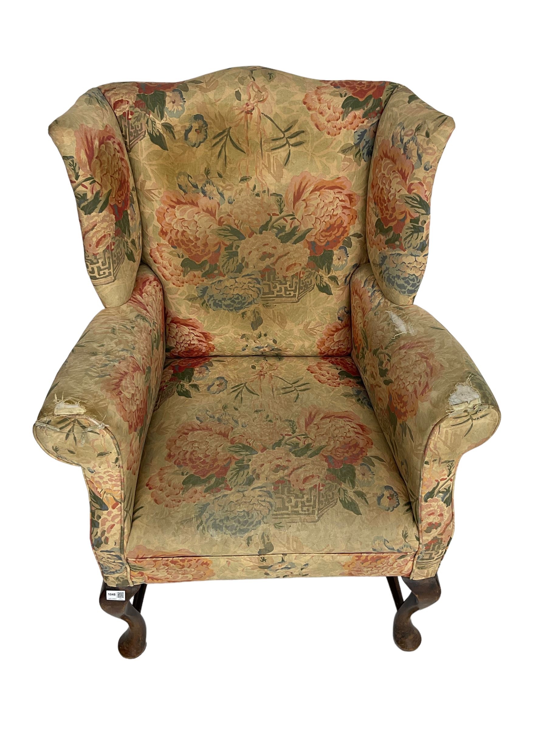 Early 20th century Georgian style wingback armchair, upholstered in floral fabric with sprung seat, walnut frame with front cabriole supports