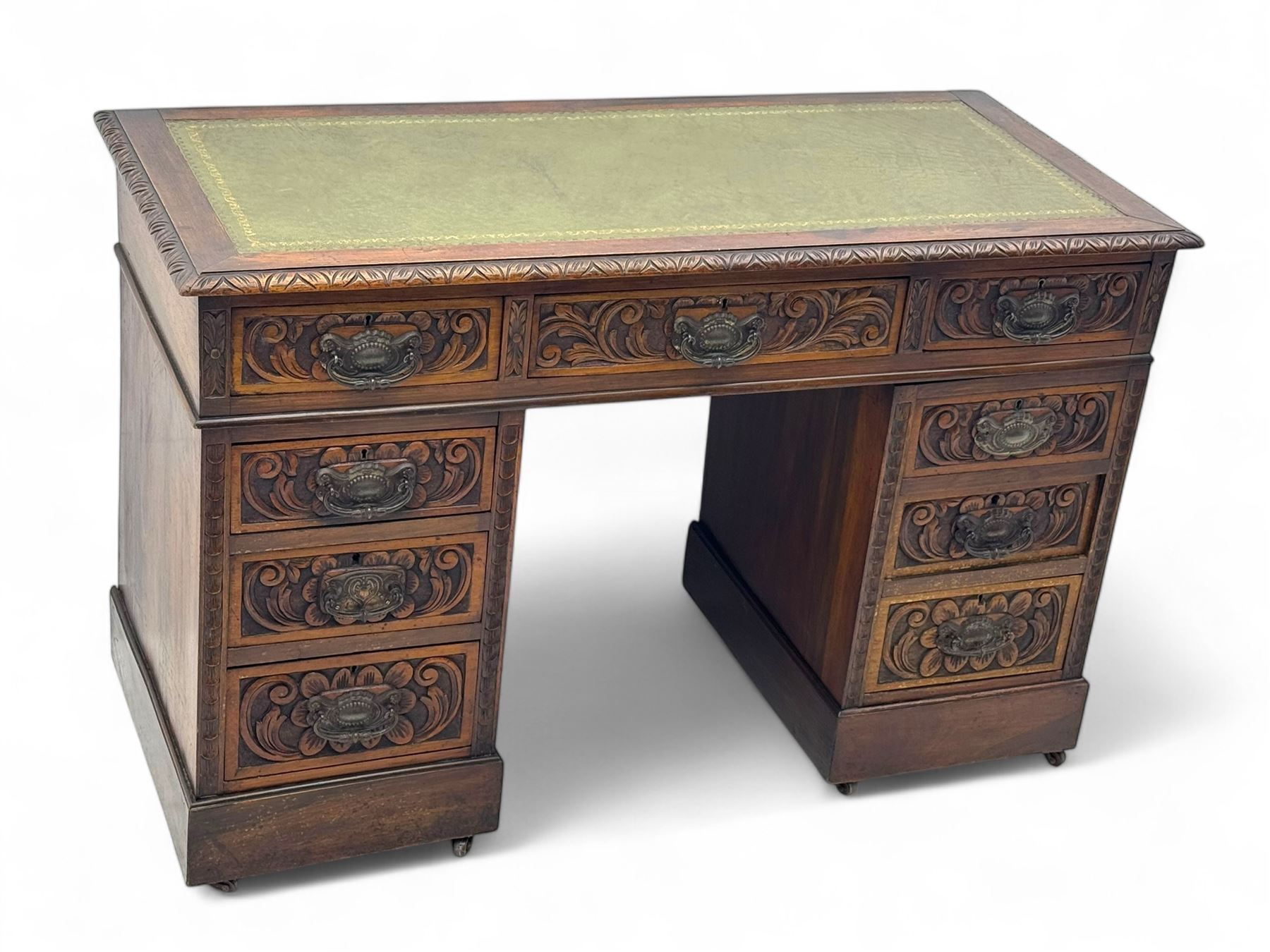 Late 19th century carved oak twin pedestal desk, rectangular top with inset leather writing surface, fitted with nine drawers, carved with scrolling foliate decoration, in three sections