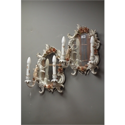  Pair 20th century German porcelain twin branch mirrors by PMP, the scroll frame having encrusted flowers and applied maiden and cherub figures, H46cm   