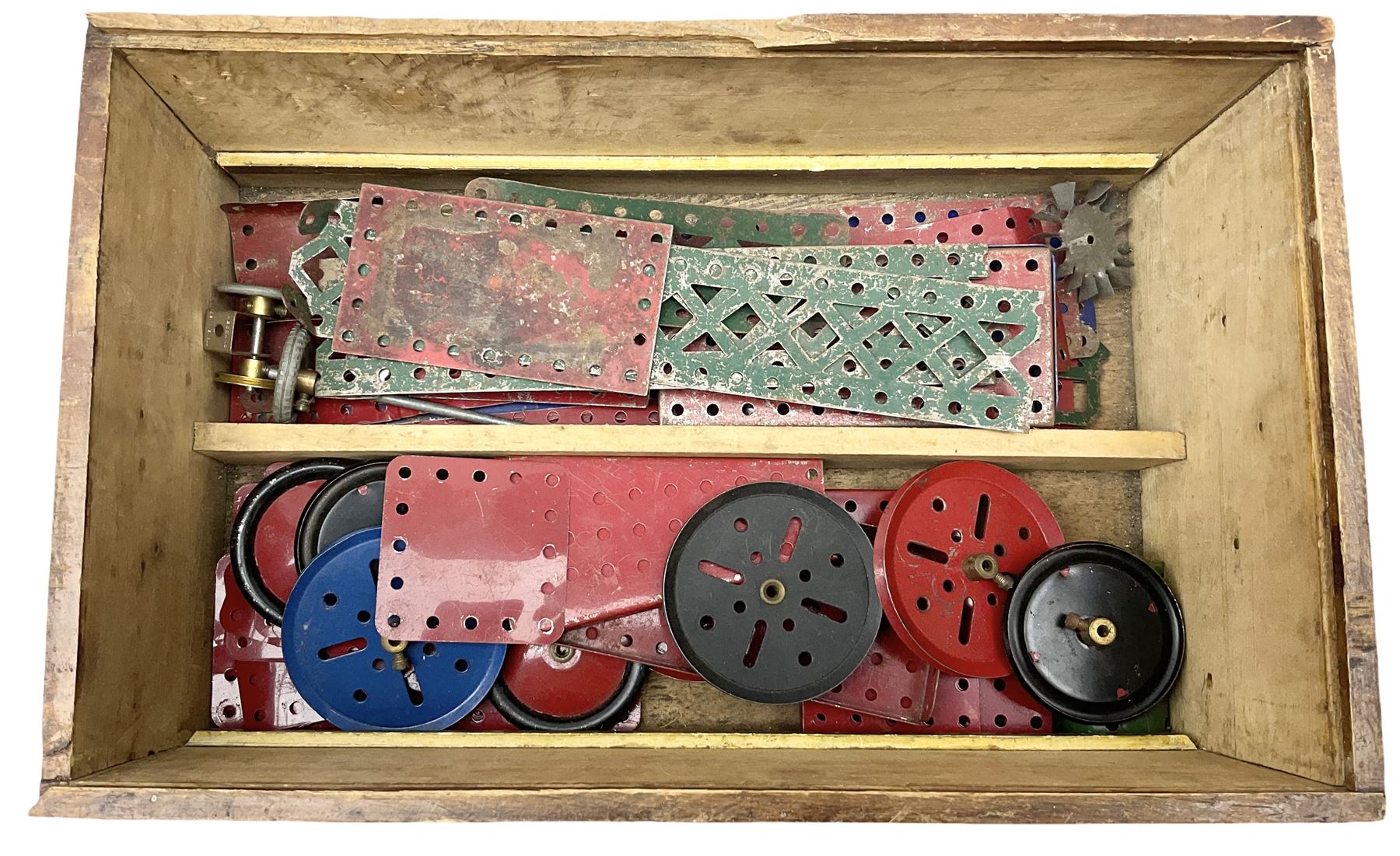 Meccano - wooden box with Set No.5 label to sliding lid, containing two lift-out trays and bottom layer of predominantly red and green sections, wheels, pulleys, rods, tyres etc, carrying handles to either end, L36cm D22.5cm H13.5cm