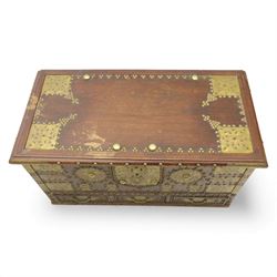 Early 20th century brass-mounted hardwood chest, the hinged top and front richly decorated with applied and studded brass panels and pierced lock escutcheon, revealing a candle box, reinforced with brass corner mounts