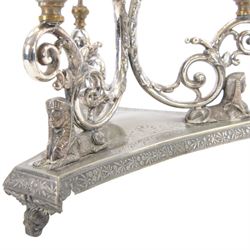 Silver plated Egyptian Revival lamp, with scrolling columns, on a trefoil base, surmounted by three sphinxes, with mask feet, H60cm