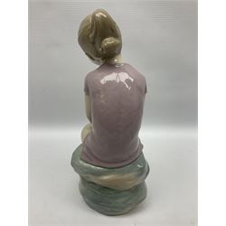 Large Nao figure modelled as a young girl seated upon a rock holding a rose, H30cm