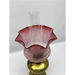 Brass oil lamp with foliate etched cranberry glass shade 