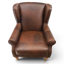Marks & Spencer - Pair of brown leather wing back chairs, raised on light stained supports with castors