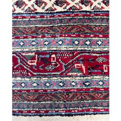 Northwestern Persian Bottehmir hand-knotted rug, ivory field with an all-over design of boteh motifs arranged in diagonal rows within multiple borders and a primary madder red field with stylized vine and flowerhead motifs, 320cm x 214cm 