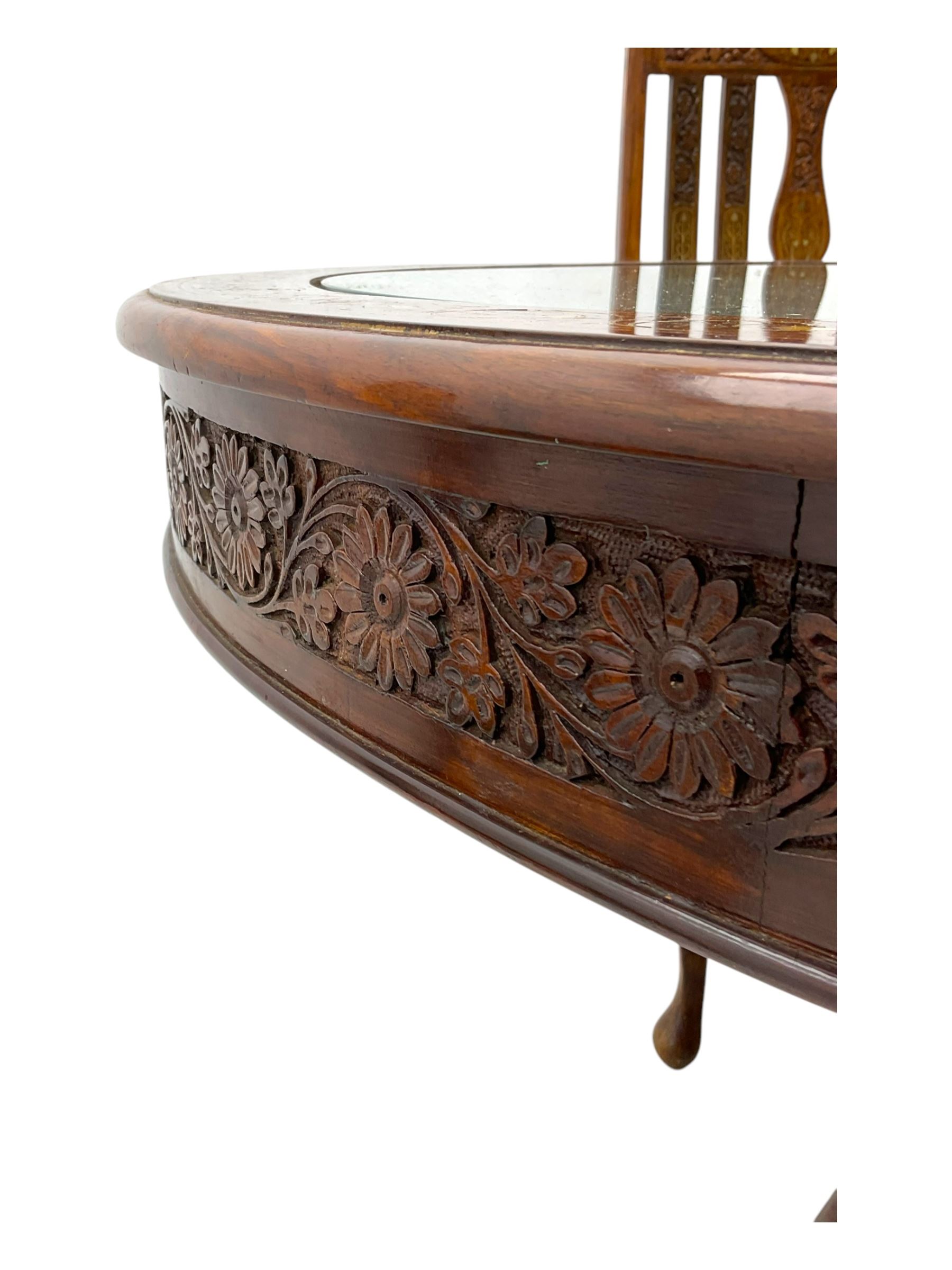 Pakistan carved hardwood brass inlaid circular dining table, and four rail back chairs with saddle seats