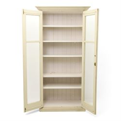 Traditional white painted pine display cabinet, projecting cornice above two glazed doors enclosing five fixed shelves, tongue and groove back raised on a plinth base