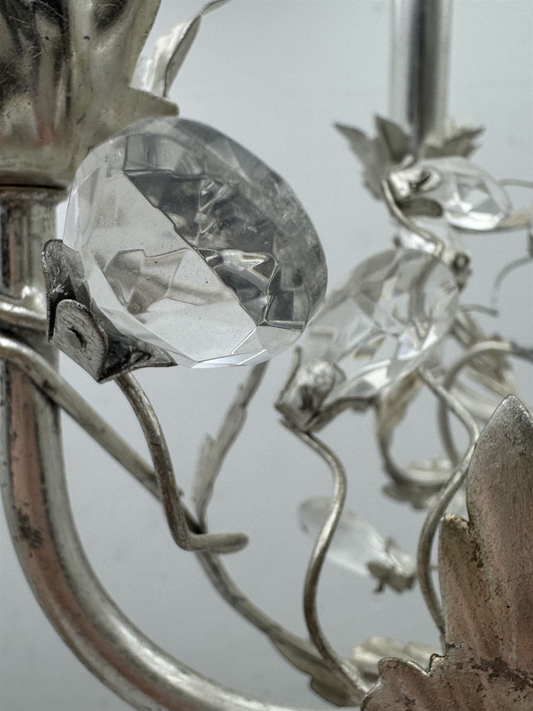 India Jane - silver finish metal chandelier, modelled with scrolling vines and leaves, embellished with faceted glass drops, fitted with six candle sconces, and wired for electricity