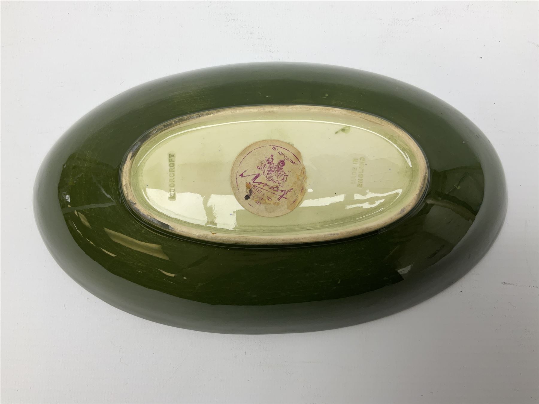Moorcroft oval bowl, decorated in the Hibiscus pattern upon a green