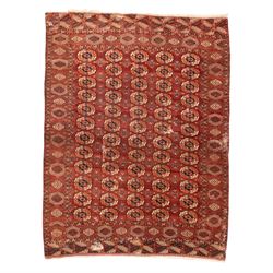 Persian Bokhara crimson ground rug, the field decorated with five rows of repeating Gul mo...