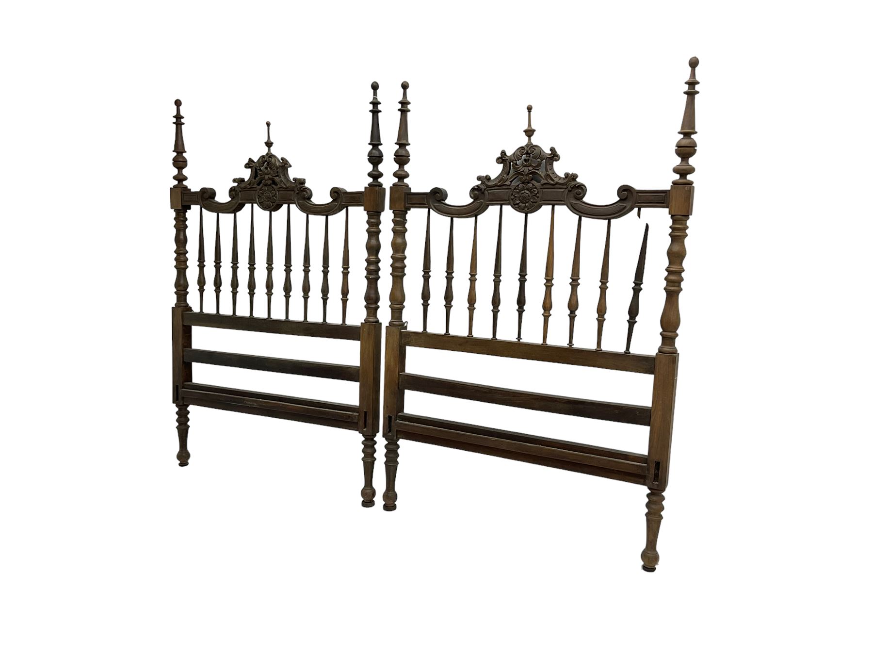 Pair Spanish stained beech single 3' bedsteads, spindle turned backs and carved with scrolling floral decoration 