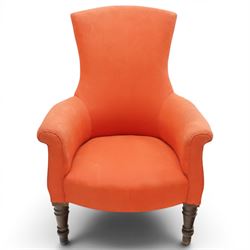 Victorian coral red upholstered armchair, the swept high back above padded arms with rolled fronts, on short turned ebonised front supports with castors