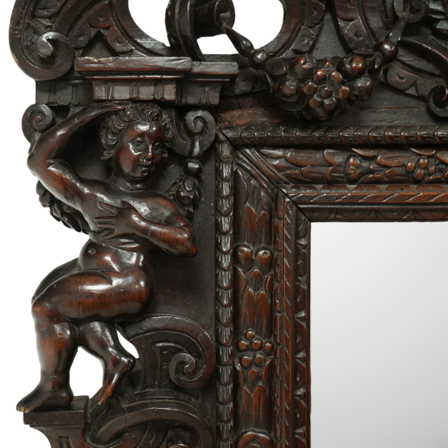 Renaissance-style mid 19th century carved fruitwood wall mirror, carved top surmounted by ‘broken’ arched pediment with central putti figure and grape vine, the sides with two putti figures above C-scroll decorations, and with a similarly carved base