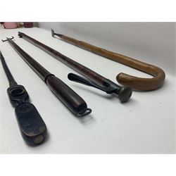 Two late 19th century fruit picker canes, the first example a French ebonised bamboo cane, with pair of fruit scissors to base, the handle stamped Cueille Fruit, the second example with grabbing action, the cap stamped A C Harris, Leicester, together with two other 19th century canes, one with fork and the other with hoe