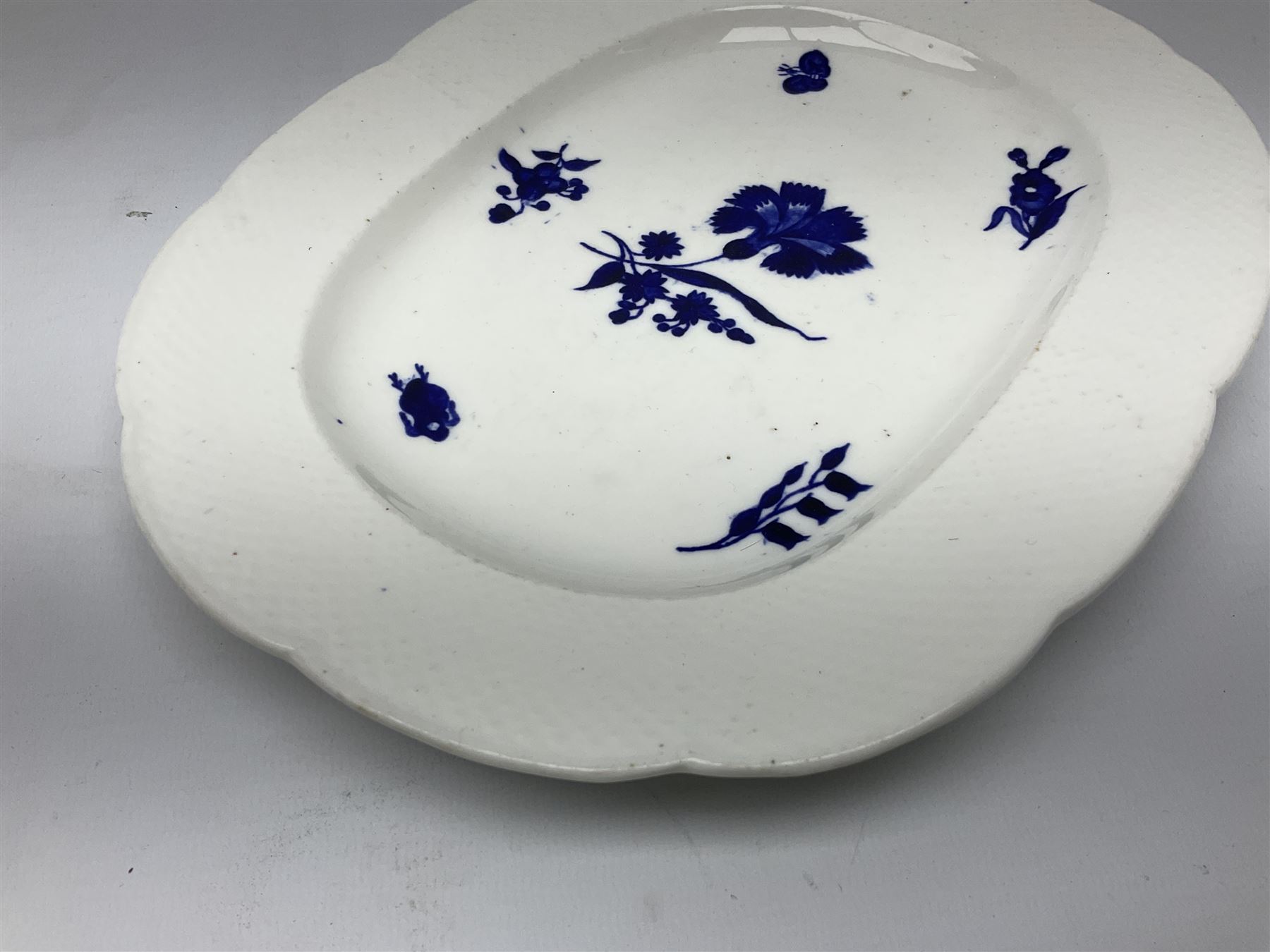 Three 19th century plates, comprising two circular examples and one oblong, each with osier moulded sides, the centres decorated in underglaze blue with Gillyflower type pattern, circular examples D25cm oblong example W27cm