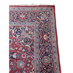 Persian Kashan red ground rug, the field decorated with scrolling foliate and stylised flower heads, floral medallion and spandrels, the main border decorated with scrolling floral design