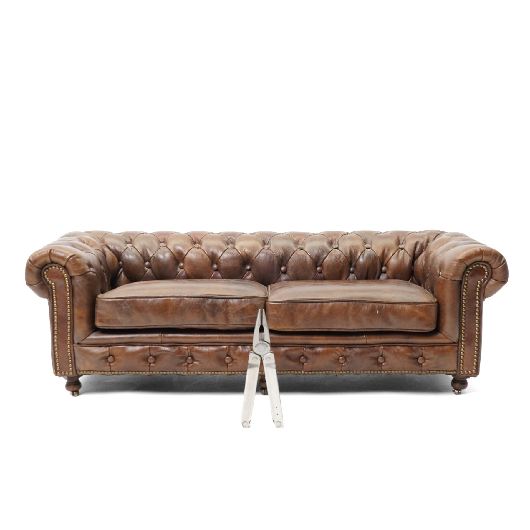Miniature brown leather button back Chesterfield sofa, with castors 