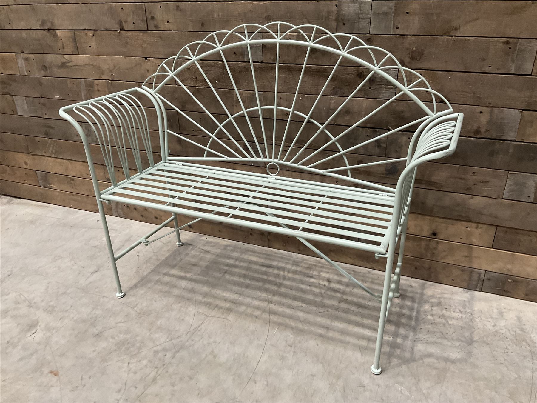 Wrought metal two seat garden bench, sunburst back, painted in pale green finish