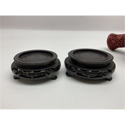 Pair of Chinese cinnabar lacquer vases, each of bulbous baluster form, carved with peonies and foo dogs amongst scrolls, with blue enamel interior and upon wooden bases, H20cm