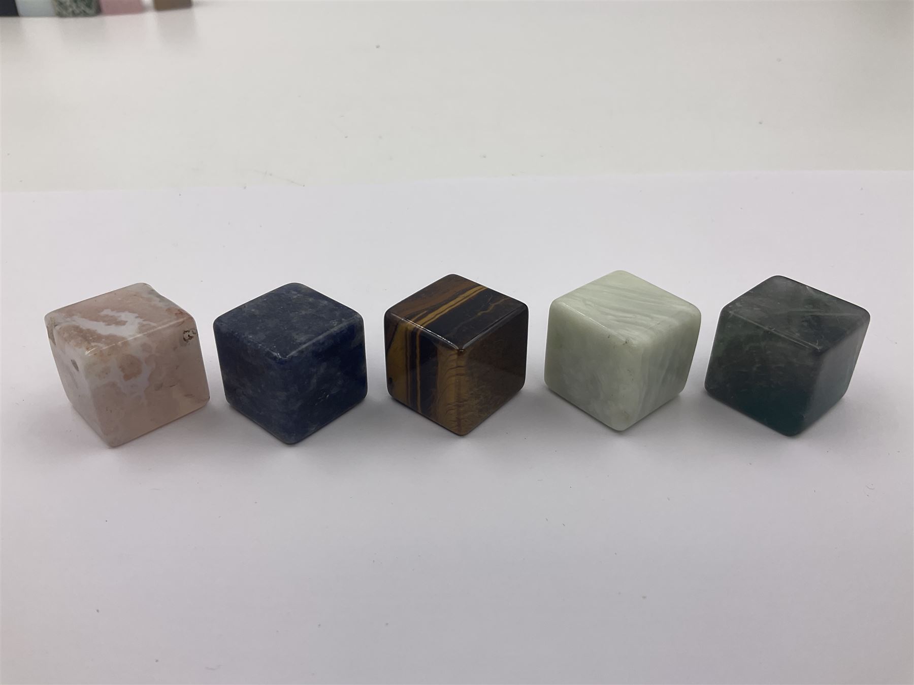 Fifteen cube mineral specimens, each cut and polished to highlight natural formations, including tiger eye, black obsidian, green aventurine, rose quartz, opalite, rhodonite etc, H2cm 