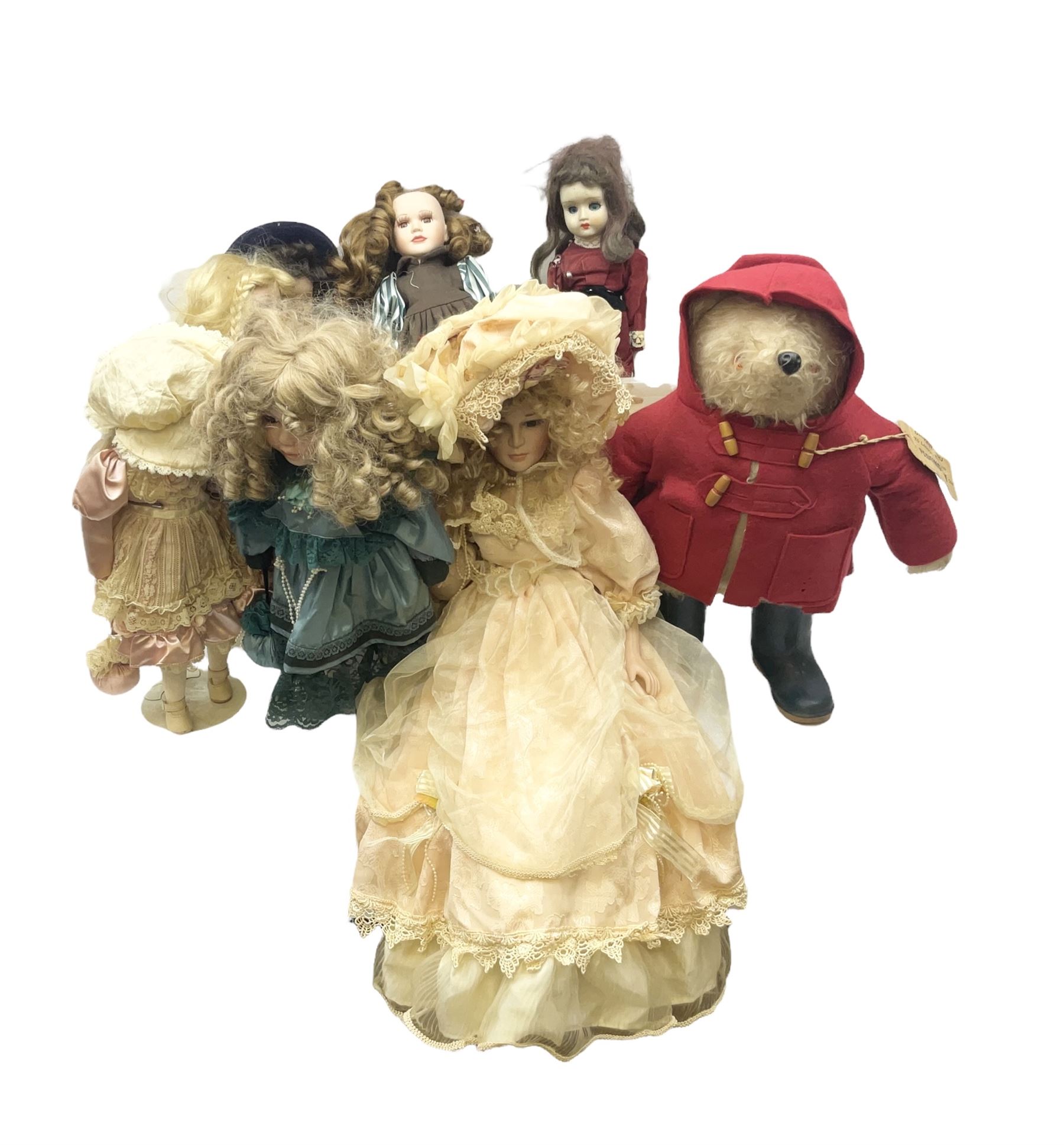 Vintage Paddington bear, with red duffle coat and hat and green Wellington boots, together with a collection of porcelain dolls, paddington H48cm 