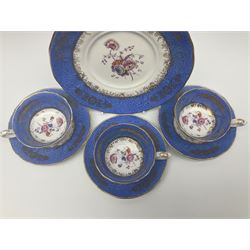 Set of three Victorian teacups and saucers, with matching dessert plate, decorated with a watered silk blue boarder and hand painted floral sprays to the centre 