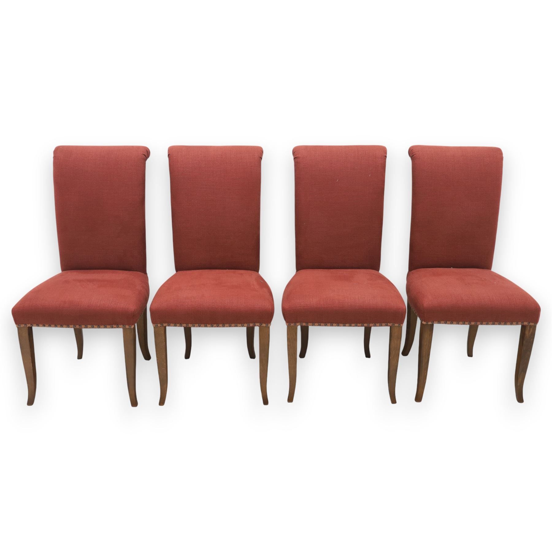 Contemporary circular painted dining table and four red upholstered chairs, table with distressed finish in black with quatriform base and bronze painted edges, chairs with 