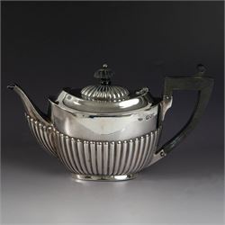 Victorian silver two piece bachelors tea service, comprising teapot and milk jug, of oval part fluted form, the teapot with ebonised wooden handle and finial, hallmarked Josiah Williams & Co, London 1895, together with a silver milk jug and open sucrier, of similar form, hallmarked William Hutton & Sons, London 1898