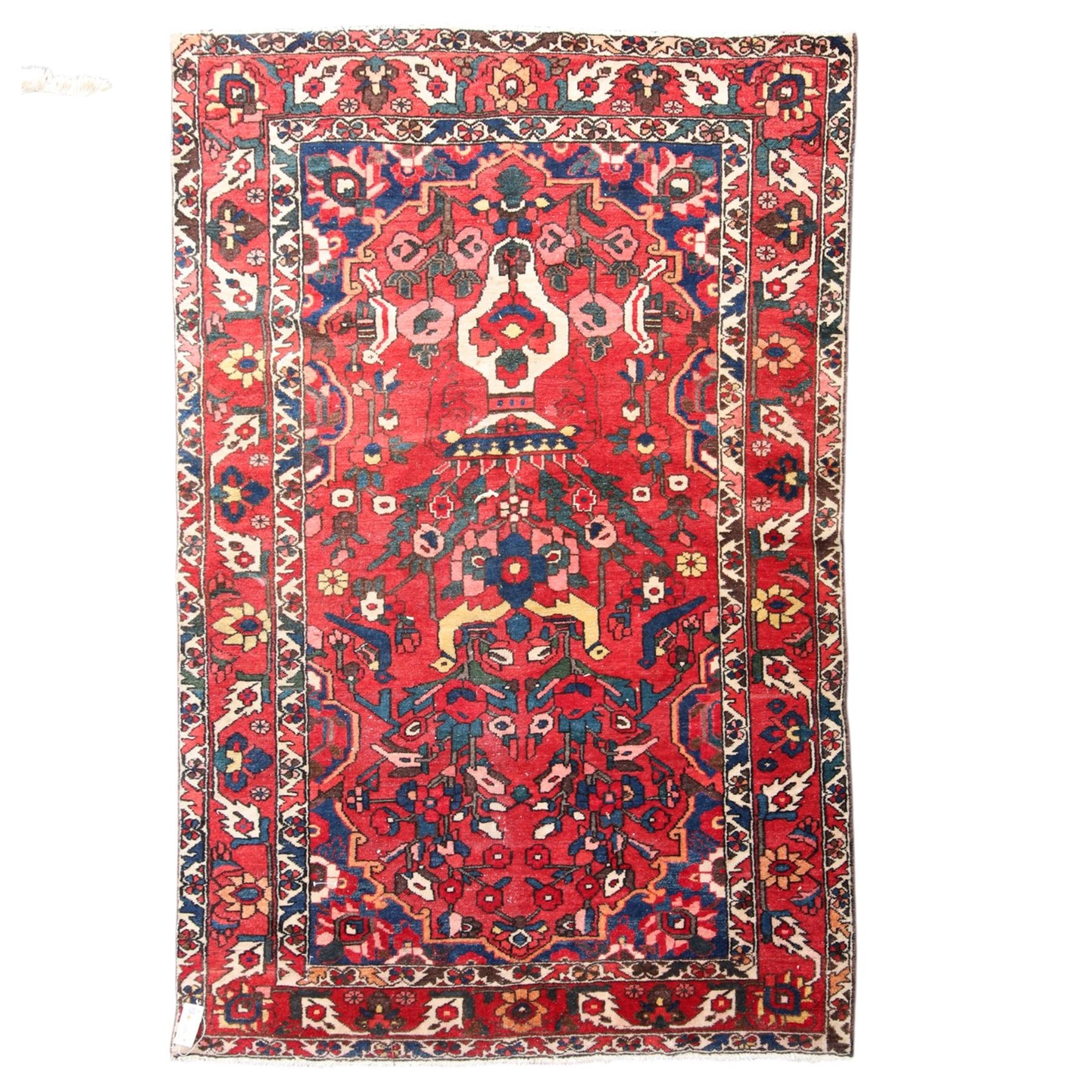 Vintage Persian Heriz crimson ground rug, the field decorated with a central stylised urn and bird of paradise motifs, the guard  lines with repeating stylised plant motifs of geometric form