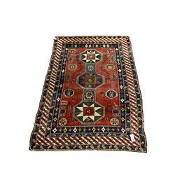 Turkish red ground rug, decorated with three medallions and geometric motifs, four band border with geometric design