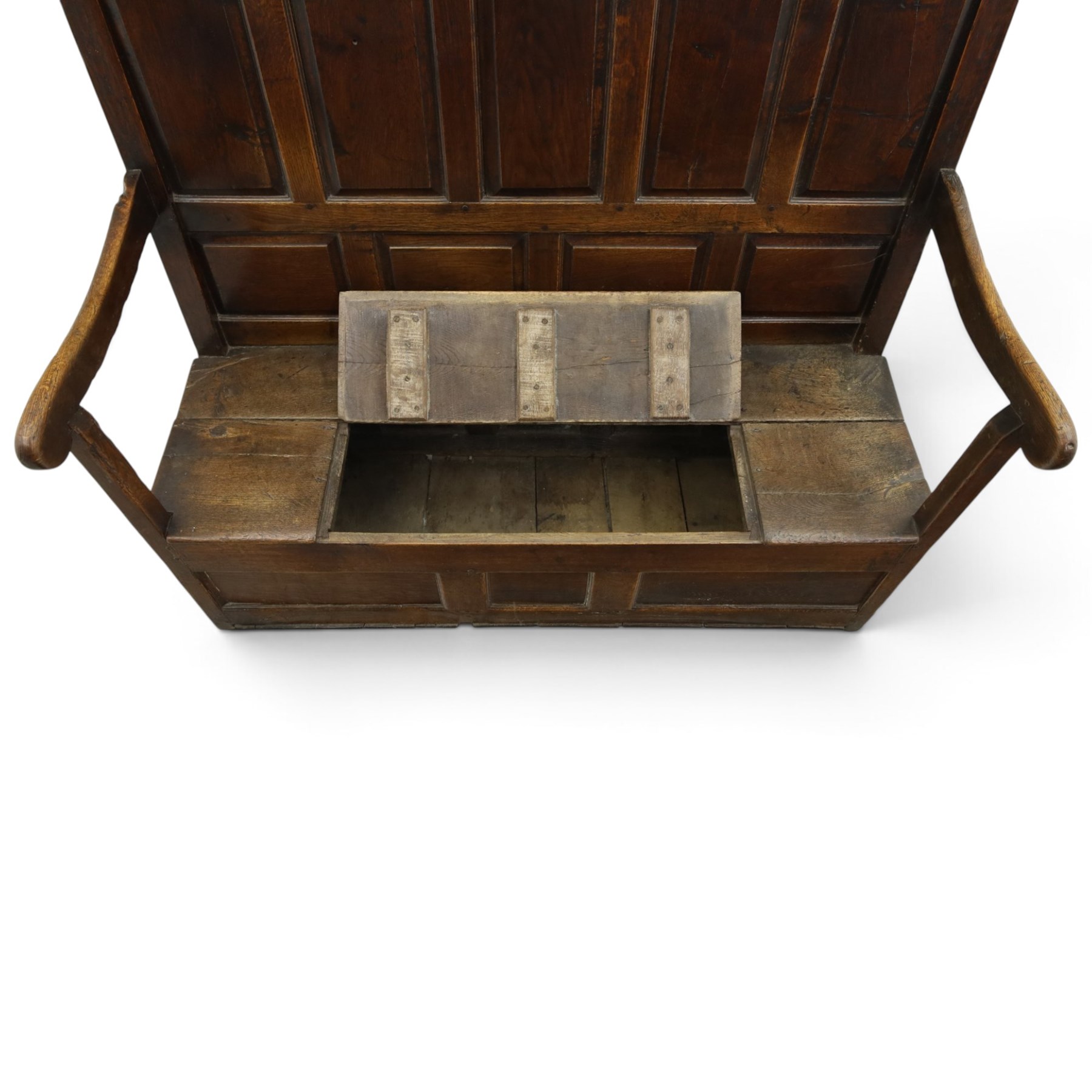 18th century oak high-back settle or hall bench, the panelled back and arm terminals over a hinged box seat, panelled front on short stile feet