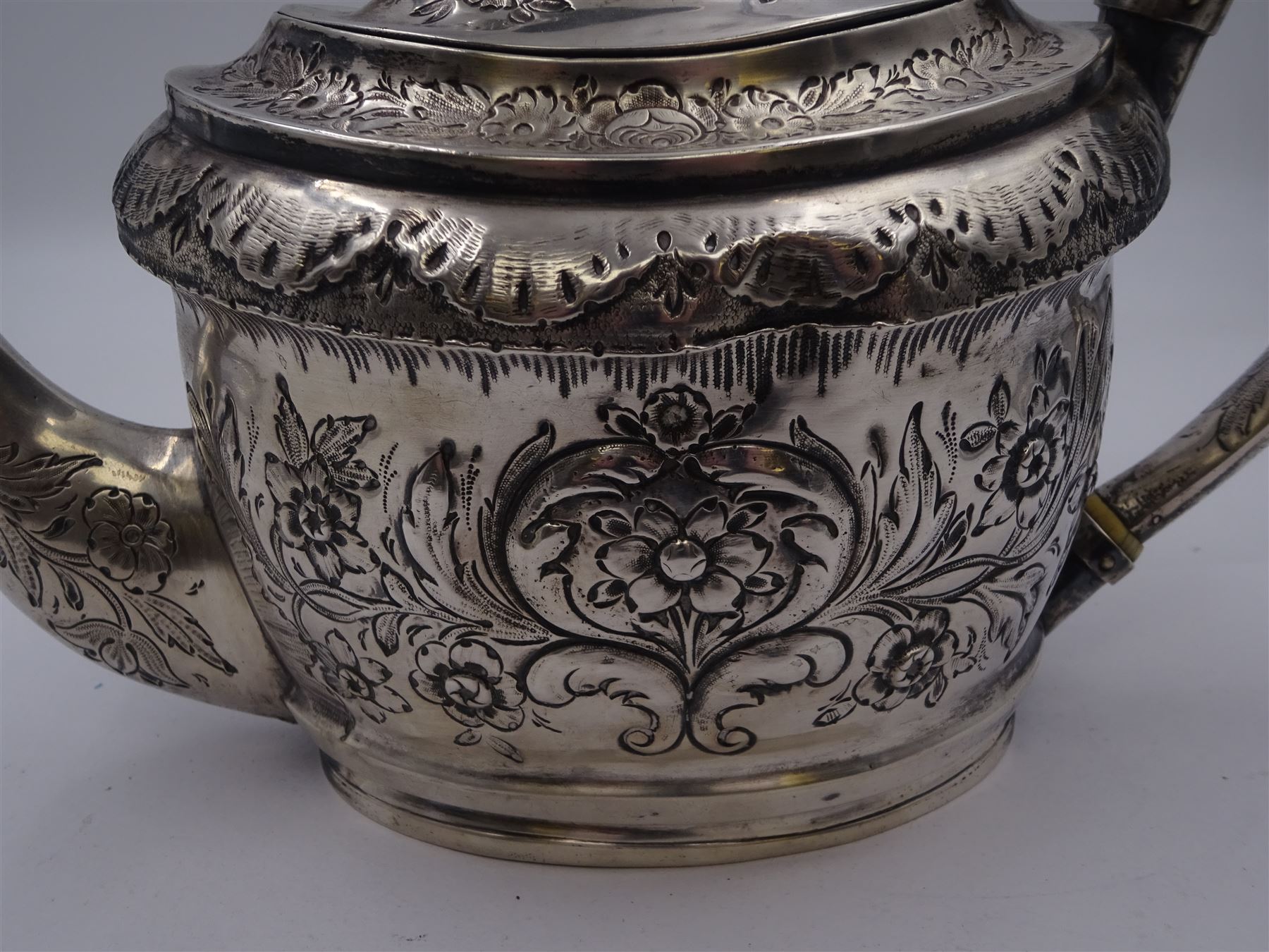 George III silver teapot, of oval form, with embossed foliate, floral and scroll decoration and engraved central cartouche, with acanthus capped C handle with ivory insulators, hallmarked John Emes, London 1807 This item has been registered for sale under Section 10 of the APHA Ivory Act
