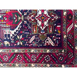 Northwestern Persian Heriz hand-knotted runner, dark indigo field with a series of linked stepped medallions in madder red, ivory, and green, flanked by angular floral motifs, within a madder red border of stylized rosettes and geometric vine motifs 405cm x 95cm