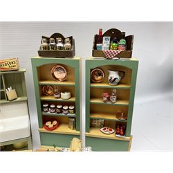 Collection of miniature dolls house kitchen ware furniture and accessories, to include illuminated period cooker, wash house sink, pair of kitchen units with various preserves etc, 1930/40s style veg prep table with duck, wall racks, chairs, various foodstuffs etc
