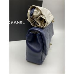 Chanel quilted flap bag of lambskin leather with light gold tone hardware,  front flap with signature CC turnlock closure, back pocket, and adjustable interwoven light gold tone chain link and navy leather shoulder strap, accompanied by Chanel box, Chanel dustbag, felt, receipt, carebook and Chanel bag