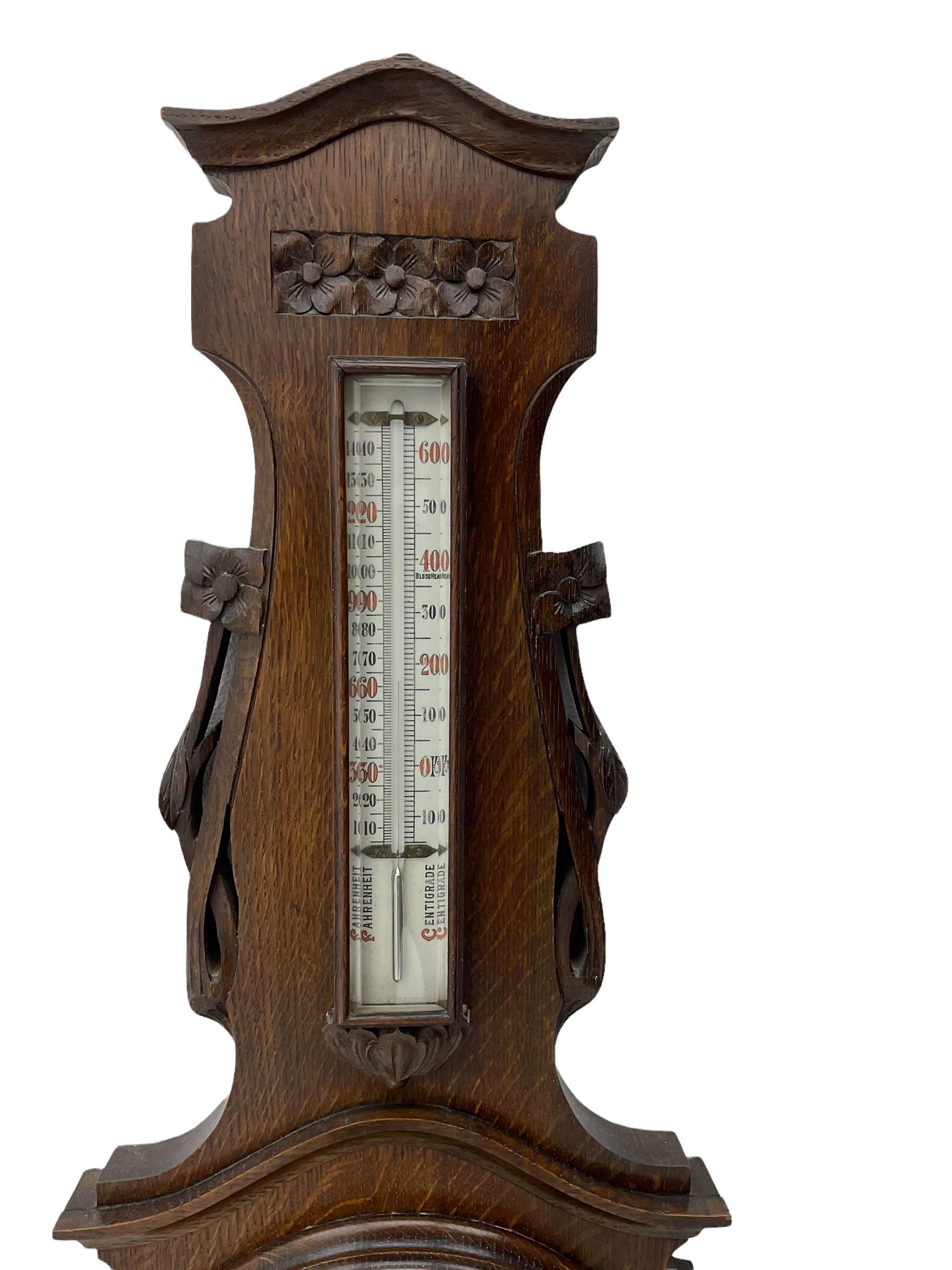 A carved oak cased aneroid barometer c1950 with an 8” open enamel dial ...