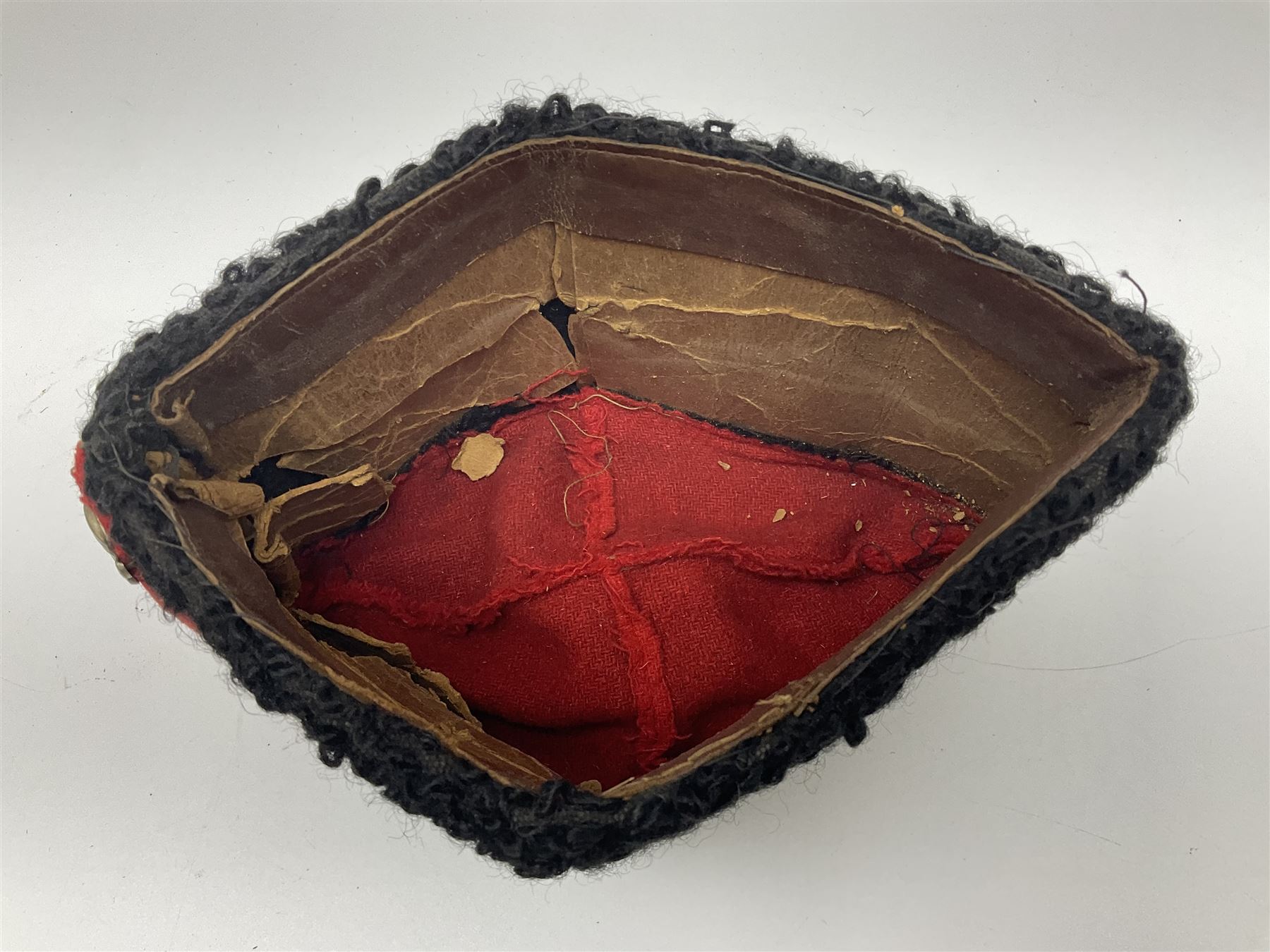 WW2 German small size Balkan style hat with 'SS' metal badges; red cloth top and flash to front with black persianelle type sides; lined in brown card with leather sweatband