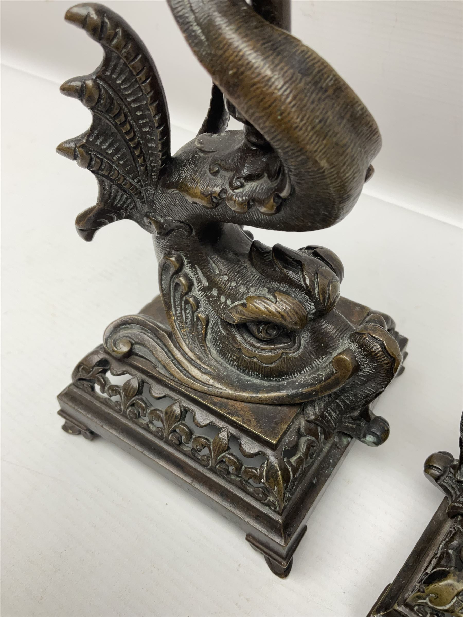 Pair of late 19th/ early 20th century brass candlesticks in the form of dolphins upon a stepped base with Fleur-de-lis design, H32cm 