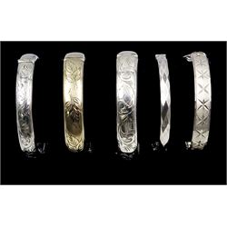 Silver-gilt bangle engraved with leaf design, Birmingham 1966 and four other silver hinged bangles, all hallmarked 