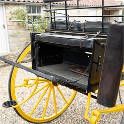 J. W. Thompson Dog Cart

A black and yellow painted two wheeled dog cart with elevated upholstered seat for two, buttoned black leather cushions, high back rail, folding front footboard, louvred sides, side steps, rear drop-down tailboard with chain stays, internal storage compartment, wooden spoked wheels, rubber tyres and shafts for a single horse. The wheel hubs are marked J W Thompson

Dimensions:
Overall length: 366 cm
Width: 160 cm
Height: 190 cm

Wheel Diameter:
Wheels: 139 cm

Seating:
Driver and passenger: 2