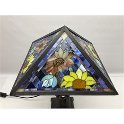 Tiffany style table lamp, the shade with four mosaic glass panels depicting sunflowers on a blue marble effect ground, raised upon a bronzed metal geometric base, H53cm