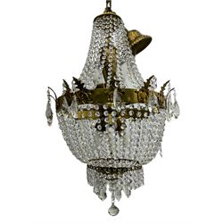 Empire design brass and crystal chandelier, the two circular brass tiers with foliate mounts, connecting the cascading crystal garlands, with prismatic drops