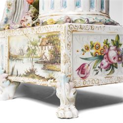 Large19th century  German porcelain mantel clock with white dial and striking movement, the case with a standing figure of Flora resting on a pillar with floral applied decoration, the base painted eith landscape and floral panels on paw feet H77cm W43cm