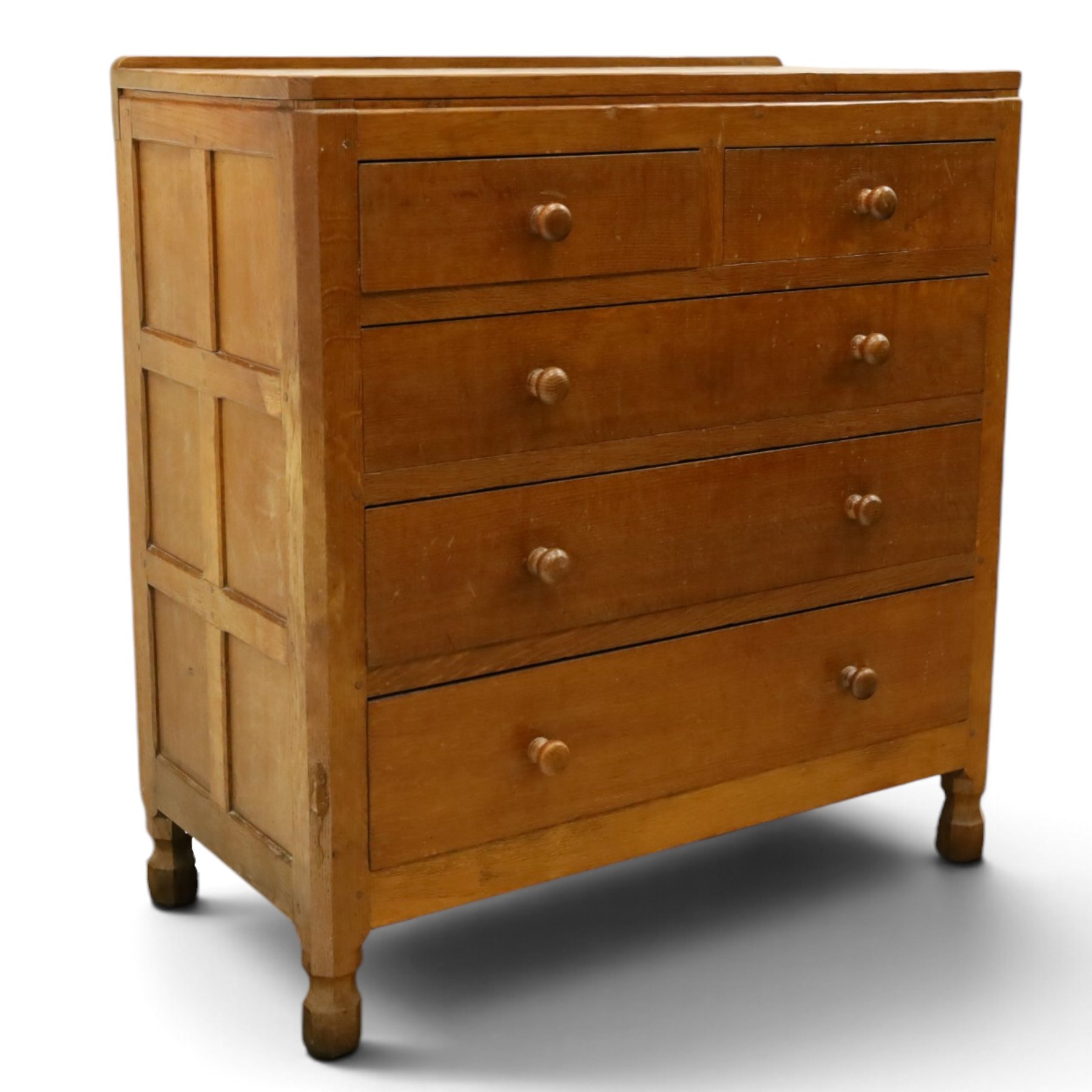 Mouseman - early-to-mid 20th century adzed and panelled oak chest, raised back over rectangular adzed top with canted corners, fitted with two short over three long drawers with turned knob handles, raised on octagonal feet, with carved mouse signature, by the workshop of Robert Thompson of Kilburn