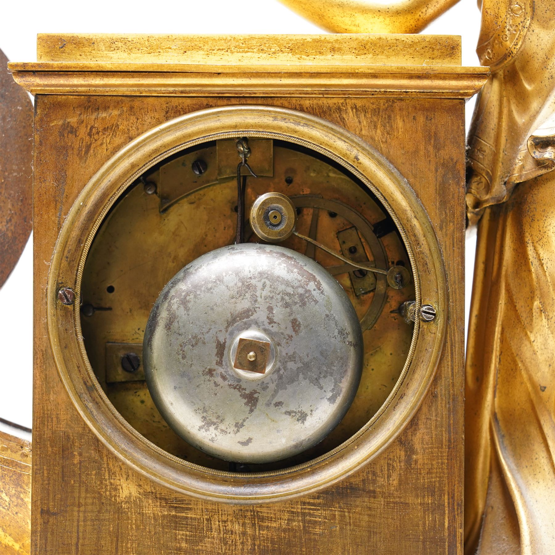 Empire period-gilt brass early 19th century French figural mantel clock c1820, the case surmounted with a figure of Ceres the Roman goddess of plenty holding a cornucopia overflowing with fruit and corn, supported on a rectangular plinth base with depictions of putti representing the arts and labour, movement case with floral garlands and a leaf and ribbon dial bezel, convex white enamel dial with moon hands and short Roman numerals, with a  Parisian 8-day twin-train countwheel striking movement and silk suspension, striking the hours and half-hours on a bell.
With pendulum and key. 