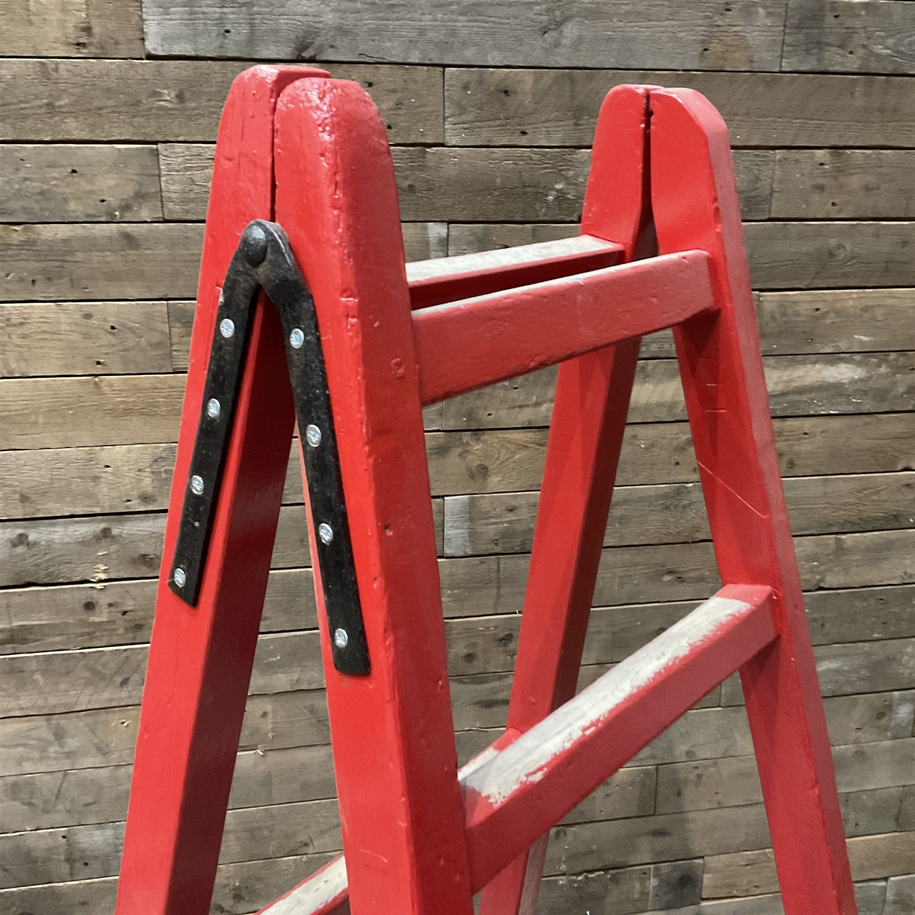 Pair of vintage red painted A frame trestles, with original A W Oates Painter signage