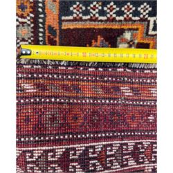 Southwestern Persian Qashqai hand-knotted carpet, the field with a lattice of hexagonal medallions in rust, indigo, and ochre, each containing stylised tree and floral motifs, flanked by lozenge panels with geometric designs, enclosed by multiple borders with rosettes and leaf motifs